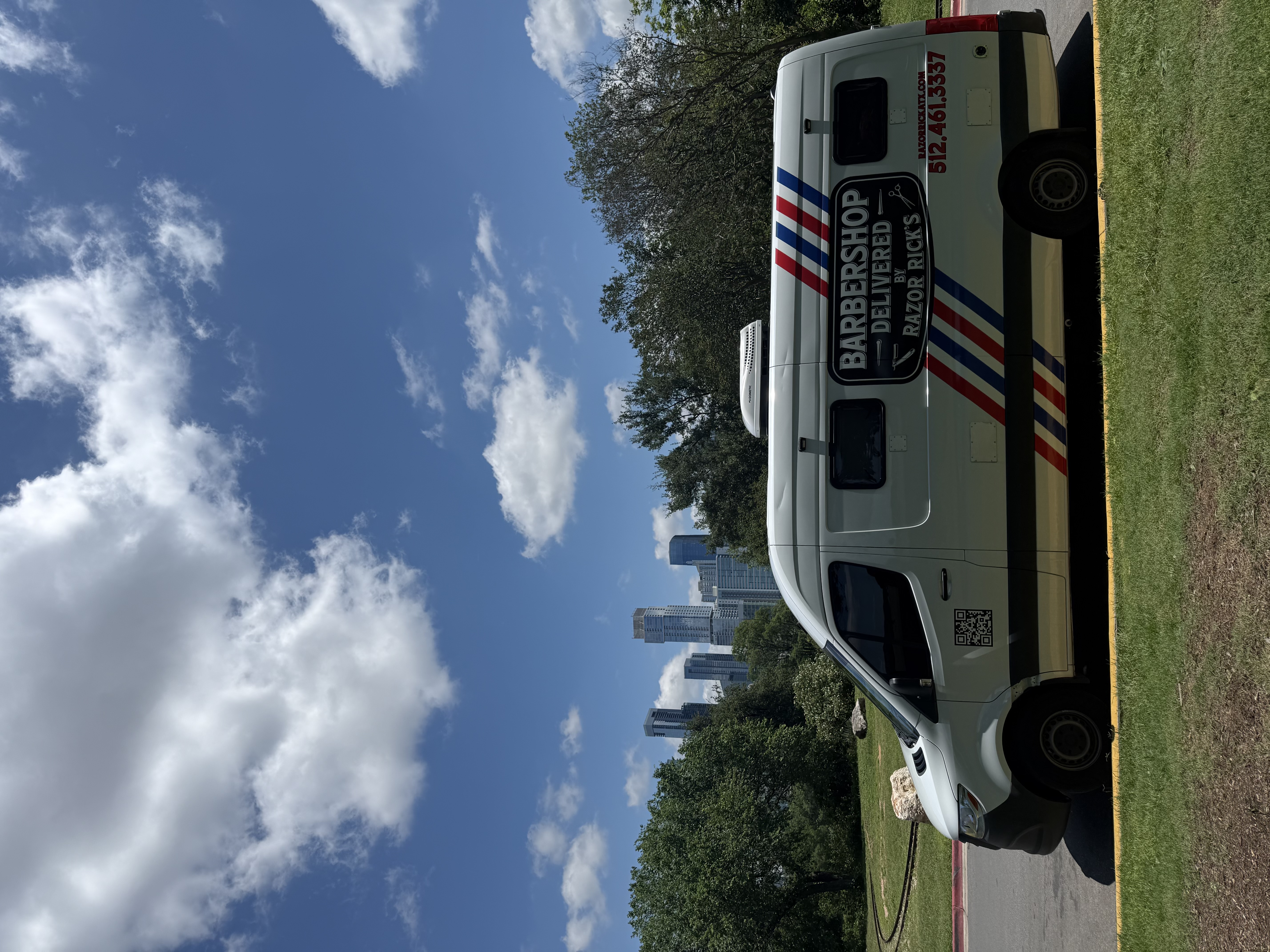 Razor Rick's Barbershop ATX mobile barbershop parked in Austin with downtown skyline